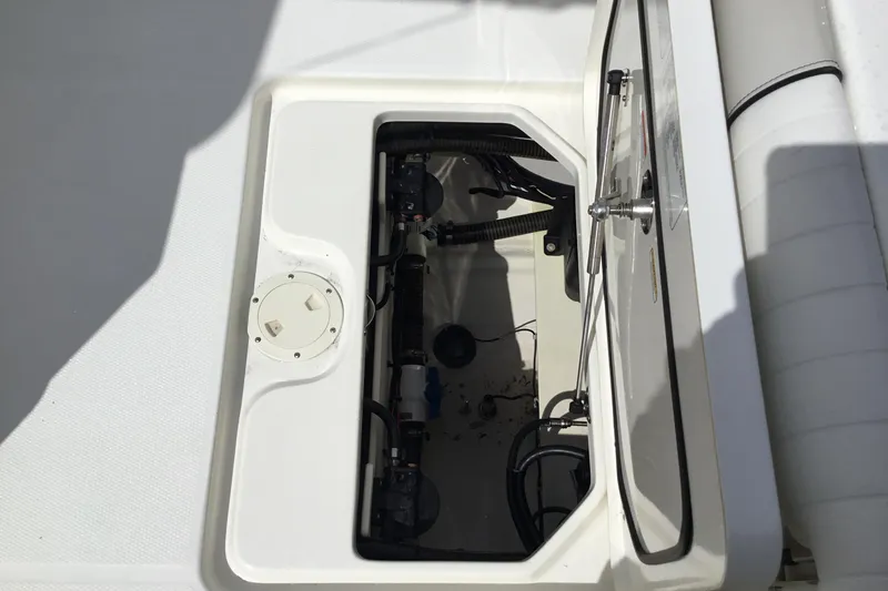 Slide: The Image of Open hatch of 2016 Mako 284 Center Console boat showing internal components. - 33