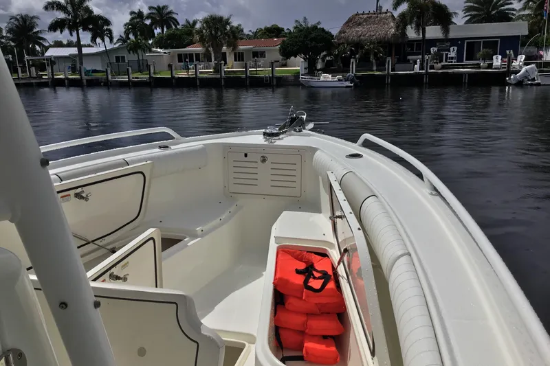 Slide: The Image of 2016 Mako 284 Center Console boat with life jackets, docked near waterfront homes. - 4