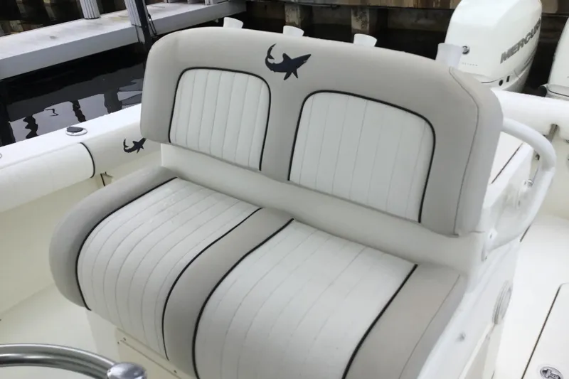 Slide: The Image of 2016 Mako 284 Center Console boat with cushioned seating and shark logo. - 46