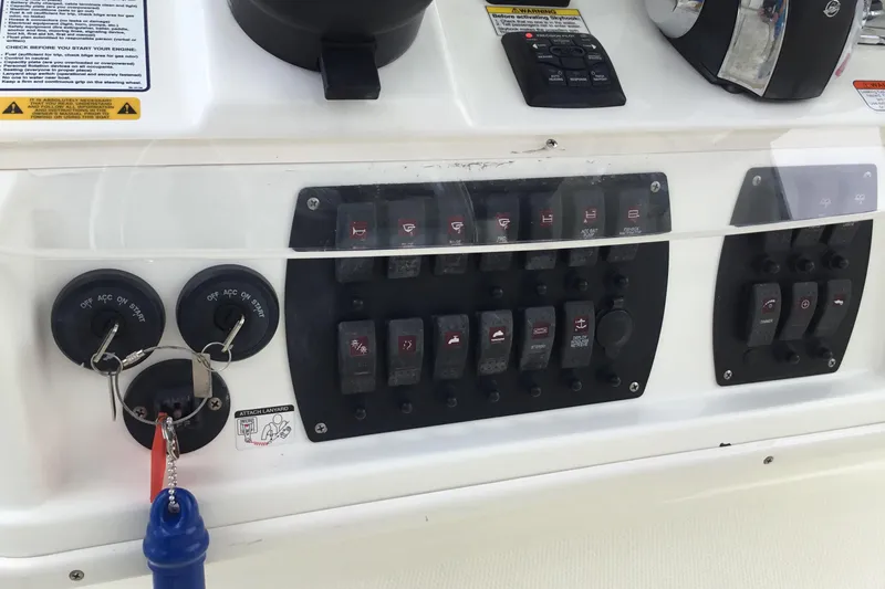 Slide: The Image of Control panel of a 2016 Mako 284 Center Console boat with switches and ignition keys. - 47