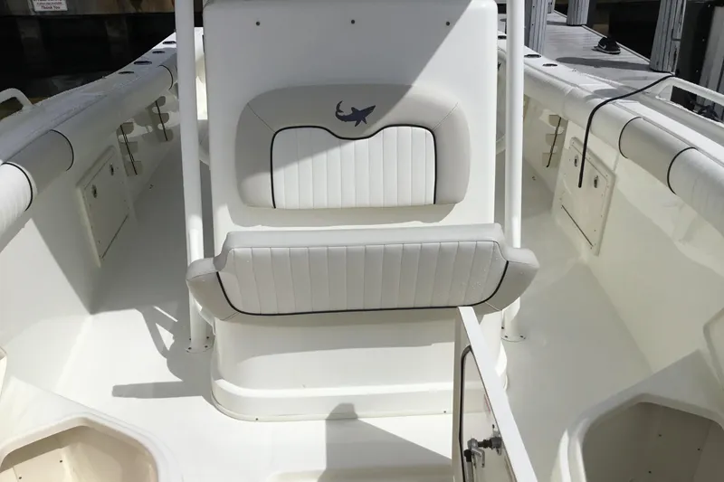 Slide: The Image of 2016 Mako 284 Center Console boat interior with white seating and storage compartments. - 6