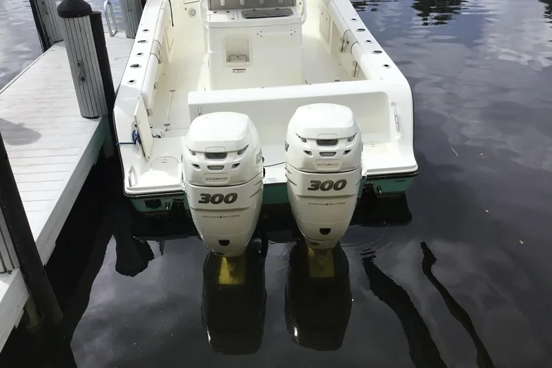 Slide: The Image of 2016 Mako 284 Center Console boat with twin 300 horsepower engines docked on calm water. - 61