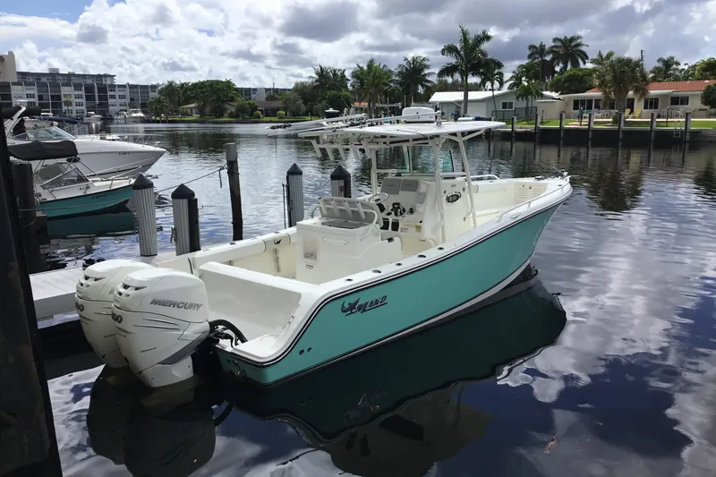 Slide: The Image of 2016 Mako 284 Center Console boat docked in a serene marina setting. - 63