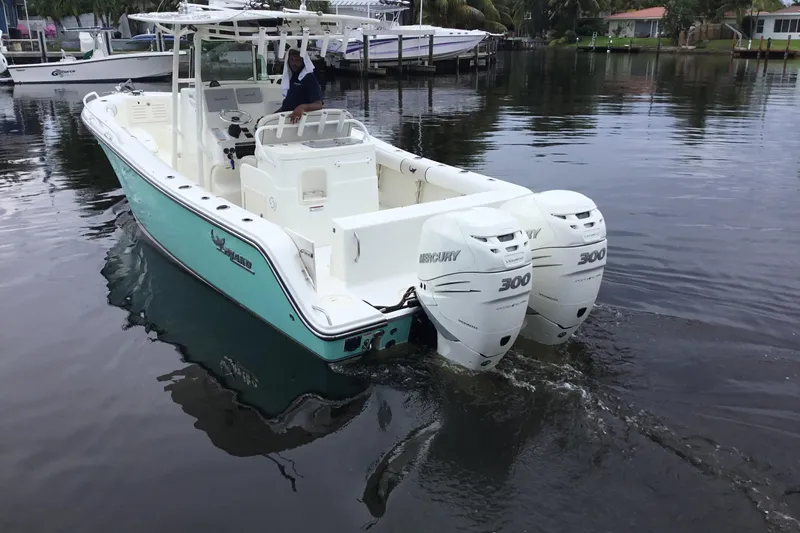 Slide: The Image of 2016 Mako 284 Center Console boat with twin Mercury 300 engines on calm water. - 64
