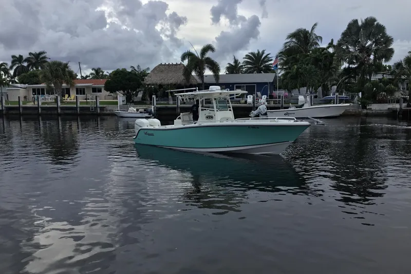 Slide: The Image of 2016 Mako 284 Center Console boat on a calm waterway with palm trees. - 73