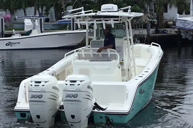 Slide: The Image of 2016 Mako 284 Center Console boat with twin Mercury engines on the water. - 77