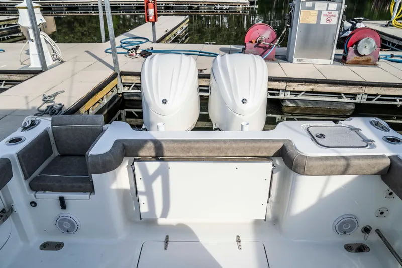 Slide: The Image of 2026 Sea Hunt Gamefish 28 boat with dual engines at a marina dock. - 10