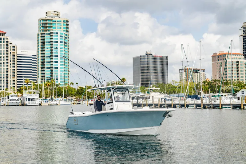 Slide: The Image of 2026 Sea Hunt Gamefish 28 boat cruising near urban marina with skyscrapers in background. - 26