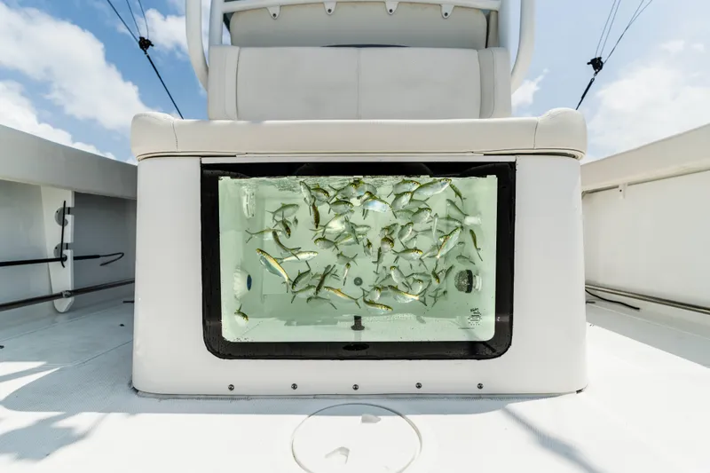Slide: The Image of 2026 Sea Hunt Gamefish 28 boat with live bait tank, forward seating, and clear water view. - 29