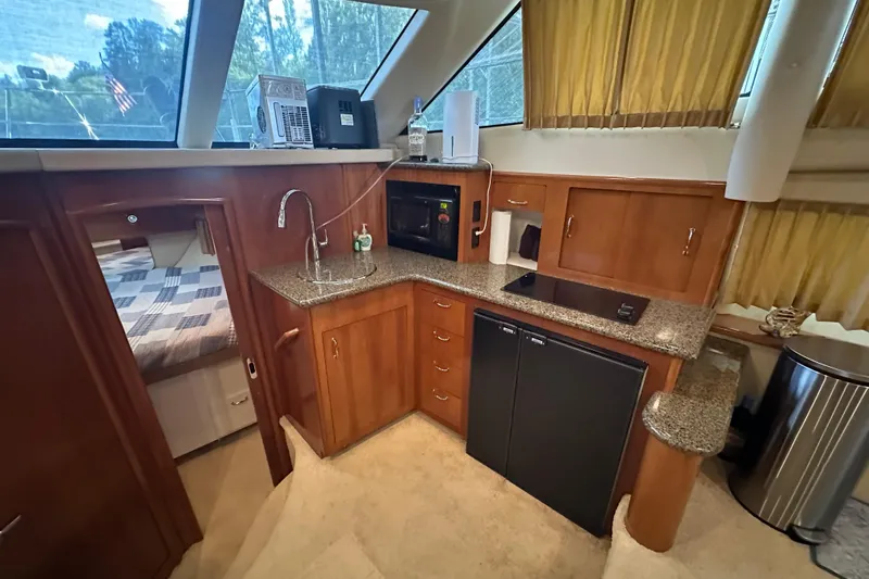 Slide: The Image of 2005 Carver 41 Cockpit Motor Yacht interior with kitchenette and bedroom view. - 7