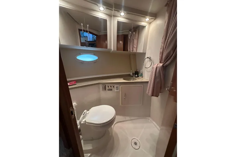 Slide: The Image of Bathroom interior of 2005 Carver 41 Cockpit Motor Yacht, featuring toilet, sink, and mirror. - 13