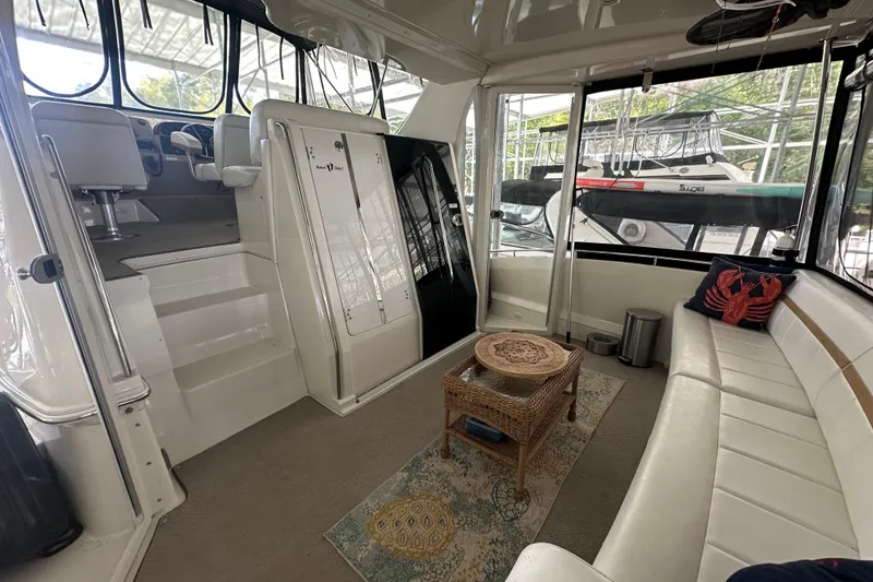 Slide: The Image of 2005 Carver 41 Cockpit Motor Yacht interior with seating, table, and helm area. - 16