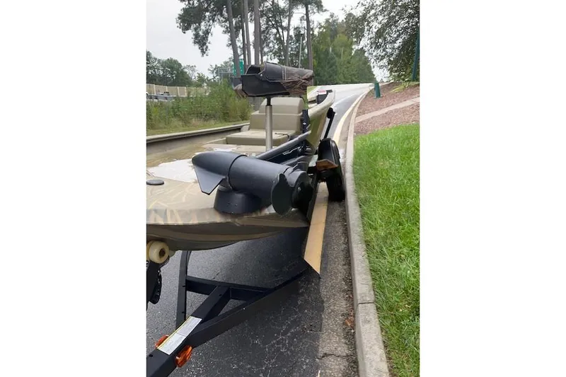 Slide: The Image of 2019 Tracker Grizzly 1754 MVX SC boat on trailer, parked on roadside. - 2