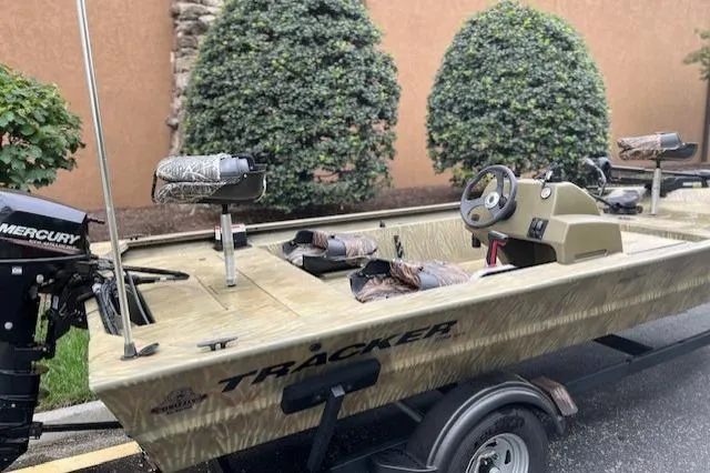 Slide: The Image of 2019 Tracker Grizzly 1754 MVX SC boat on trailer, featuring camo seats and Mercury outboard motor. - 3
