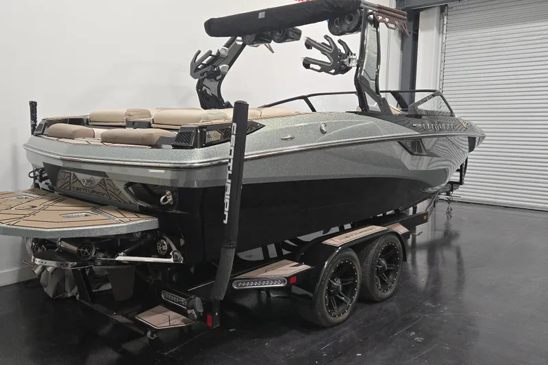 Slide: The Image of 2023 Centurion Fi23 boat in showroom, featuring sleek design and dual-axle trailer. - 4