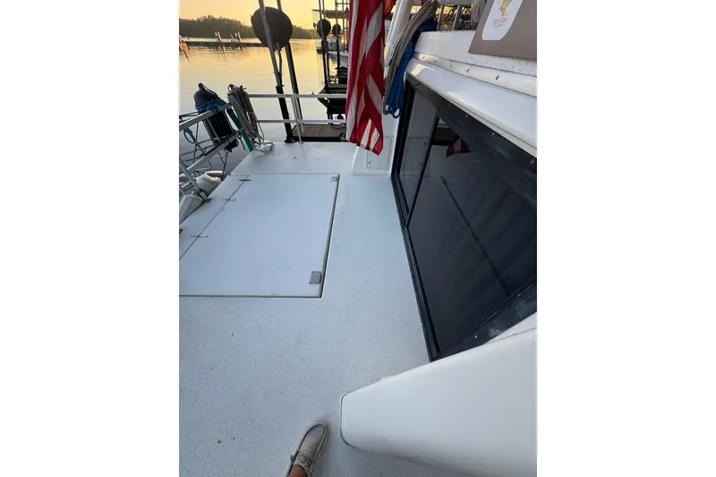 Slide: The Image of 1996 Gibson 50 Cabin Yacht deck with American flag at sunset. - 14