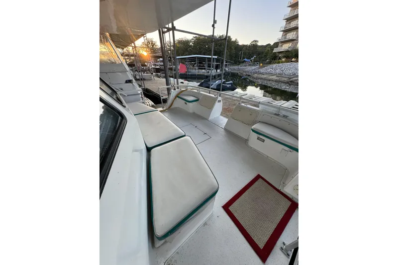 Slide: The Image of 1996 Gibson 50 Cabin Yacht deck with seating, docked at sunset. - 15