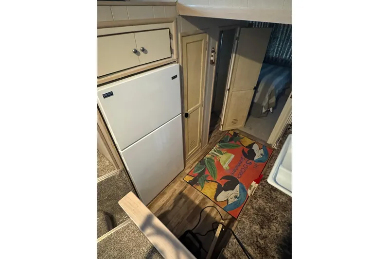 Slide: The Image of Interior of 1996 Gibson 50 Cabin Yacht with fridge, cabinets, and colorful rug. - 21