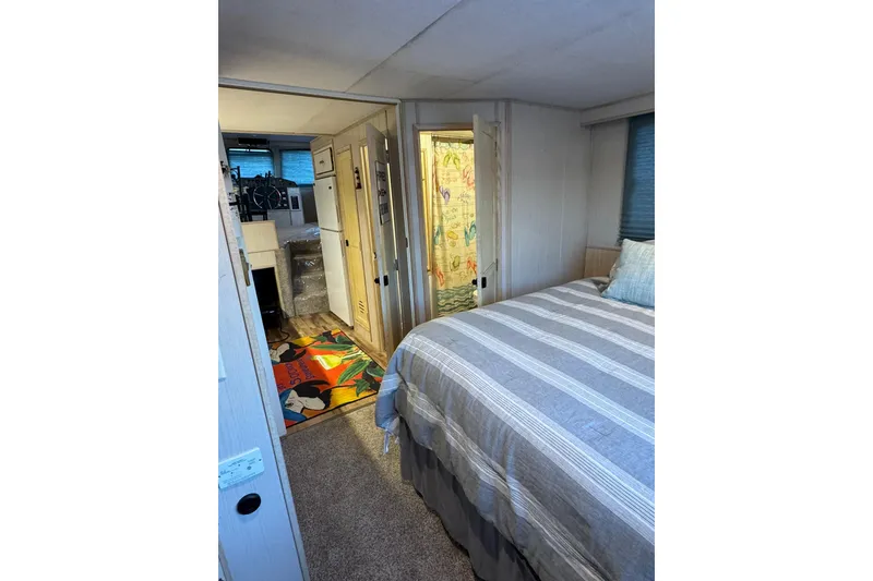 Slide: The Image of Cozy bedroom interior of 1996 Gibson 50 Cabin Yacht with striped bedding and colorful decor. - 25
