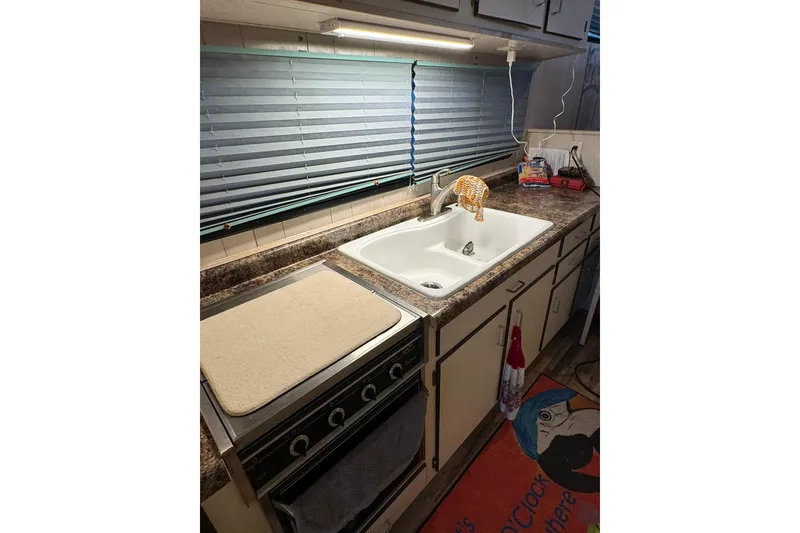 Slide: The Image of Kitchen area of a 1996 Gibson 50 Cabin Yacht with sink and stove. - 28