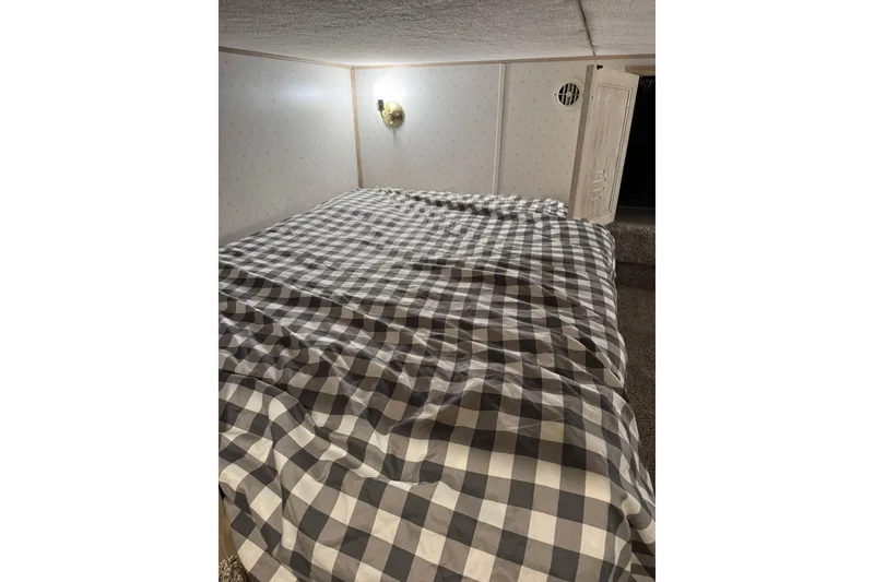 Slide: The Image of Cozy cabin bedroom with checkered bedding on 1996 Gibson 50 Cabin Yacht. - 32