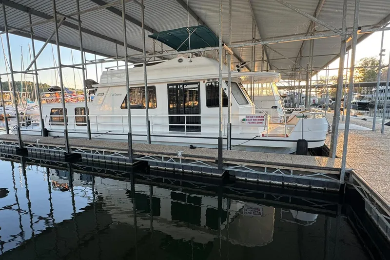 Slide: The Image of 1996 Gibson 50 Cabin Yacht docked in a marina under a covered structure. - 4