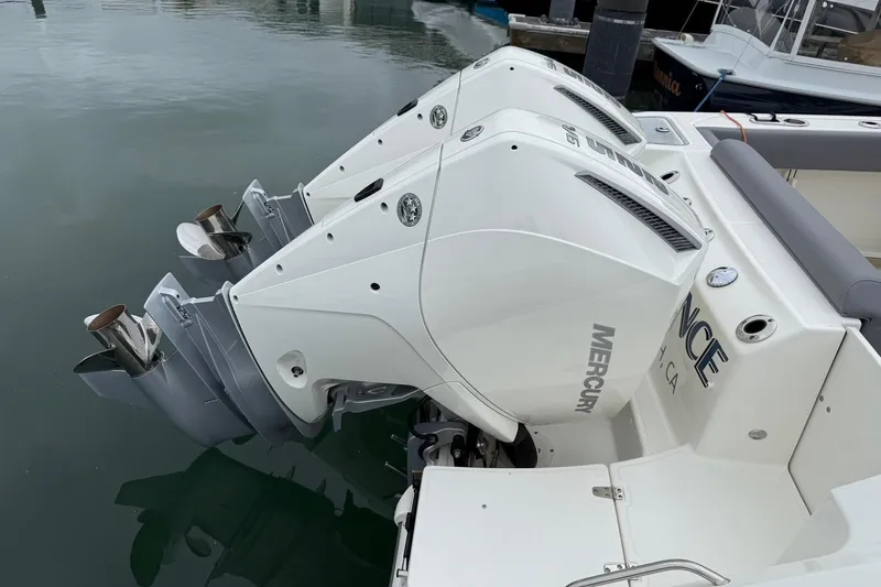 Slide: The Image of 2024 Boston Whaler 250 Outrage docked in a marina under cloudy skies. - 10