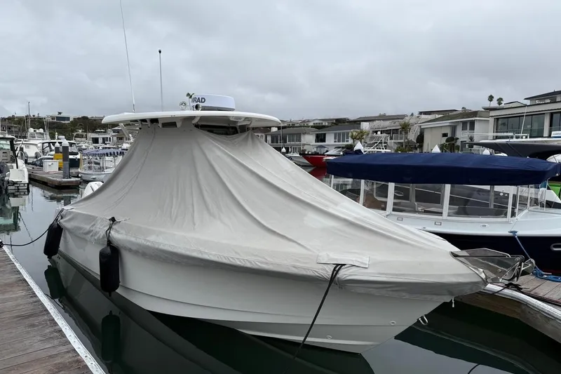 Slide: The Image of 2024 Boston Whaler 250 Outrage boat docked in a marina, overcast sky. - 11