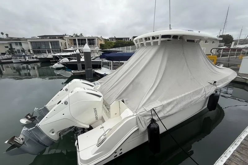 Slide: The Image of 2024 Boston Whaler 250 Outrage docked at marina, surrounded by luxury yachts. - 13