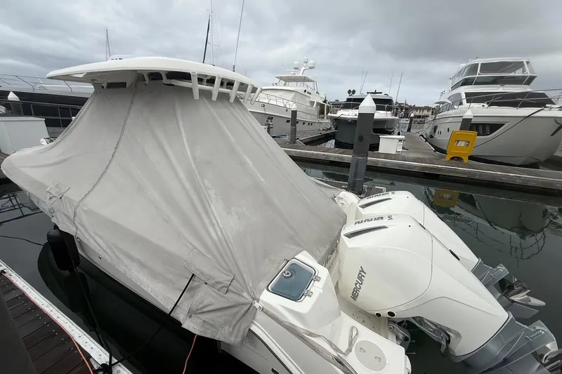 Slide: The Image of 2024 Boston Whaler 250 Outrage docked, showcasing sleek design and powerful Mercury engines. - 14