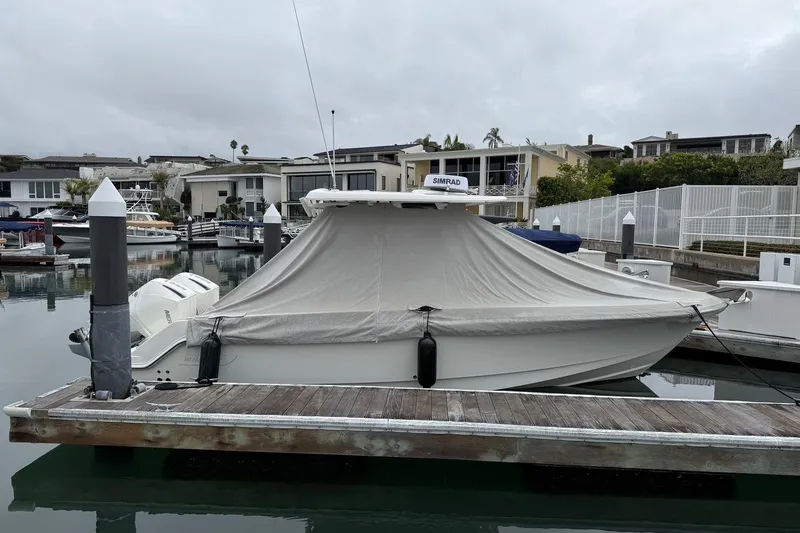 Slide: The Image of 2024 Boston Whaler 250 Outrage boat docked in marina, showcasing sleek design and powerful engines. - 15