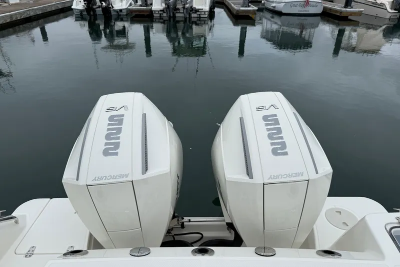 Slide: The Image of 2024 Boston Whaler 250 Outrage boat docked at marina with twin engines. - 16