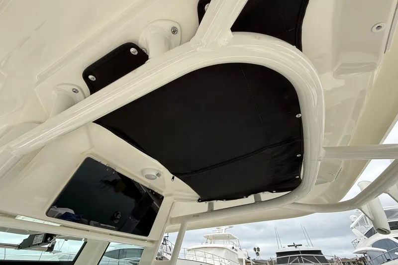 Slide: The Image of 2024 Boston Whaler 250 Outrage storage compartment with open lid and accessories. - 32