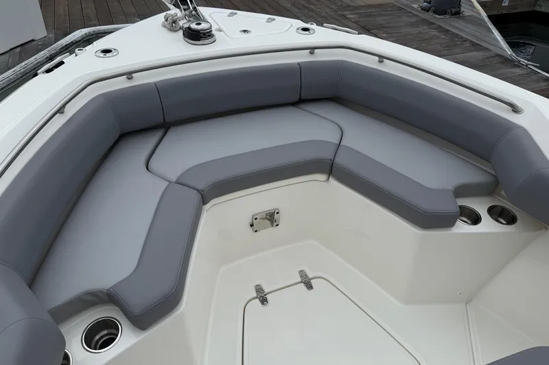 Slide: The Image of 2024 Boston Whaler 250 Outrage boat with gray cushioned seating and cup holders. - 50