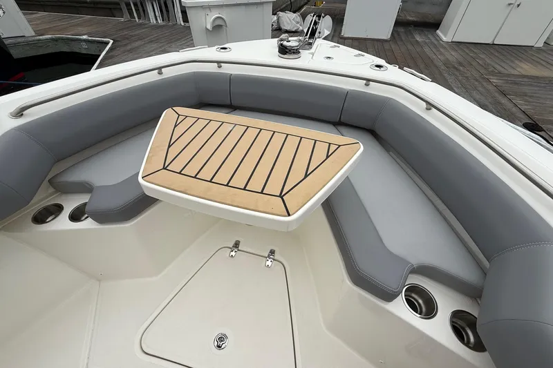 Slide: The Image of 2024 Boston Whaler 250 Outrage boat interior with cushioned seating and table. - 51