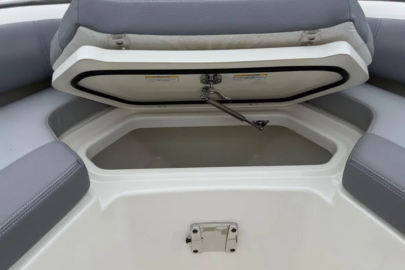 Slide: The Image of 2024 Boston Whaler 250 Outrage storage compartment with open lid and cushioned seating. - 53