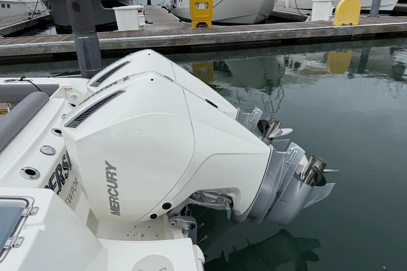 Slide: The Image of 2024 Boston Whaler 250 Outrage boat cruising in a marina with waterfront homes. - 9