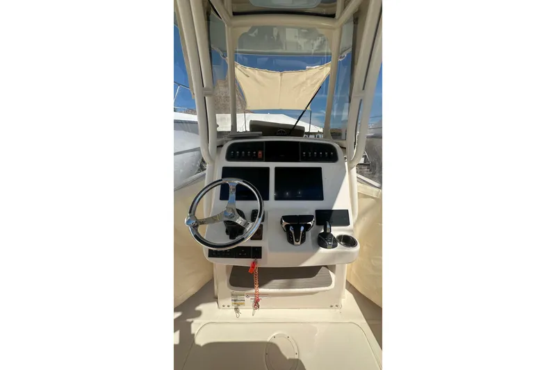 Slide: The Image of 2023 Grady-White Fisherman 257 helm with steering wheel and navigation controls. - 10