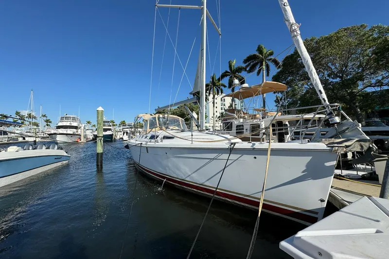 The Image of 2005 Hunter 38 sailboat docked at marina under clear blue sky. - 0