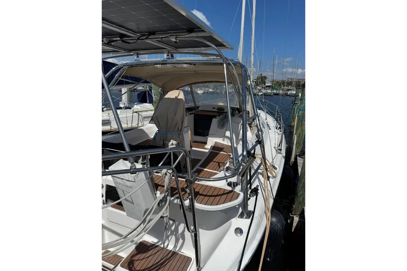 Slide: The Image of 2005 Hunter 38 sailboat docked, featuring solar panels and a spacious cockpit. - 10