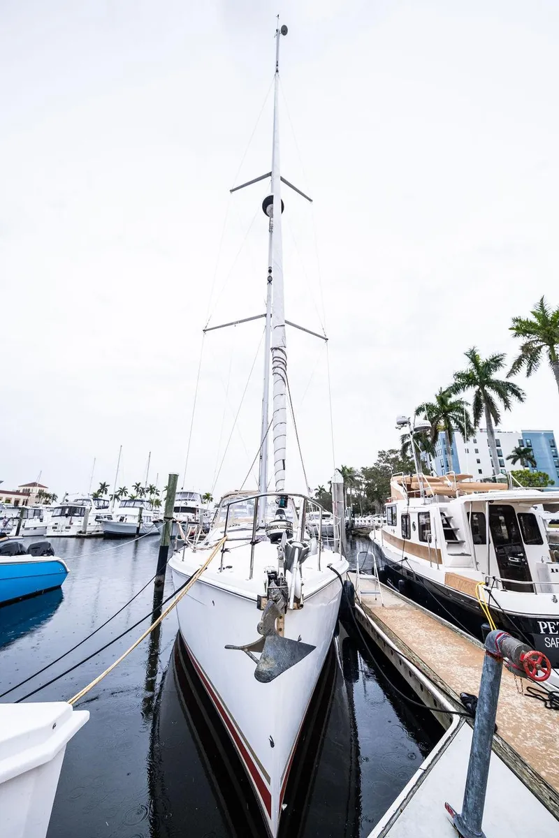 Slide: The Image of 2005 Hunter 38 sailboat docked at marina with palm trees in background. - 13