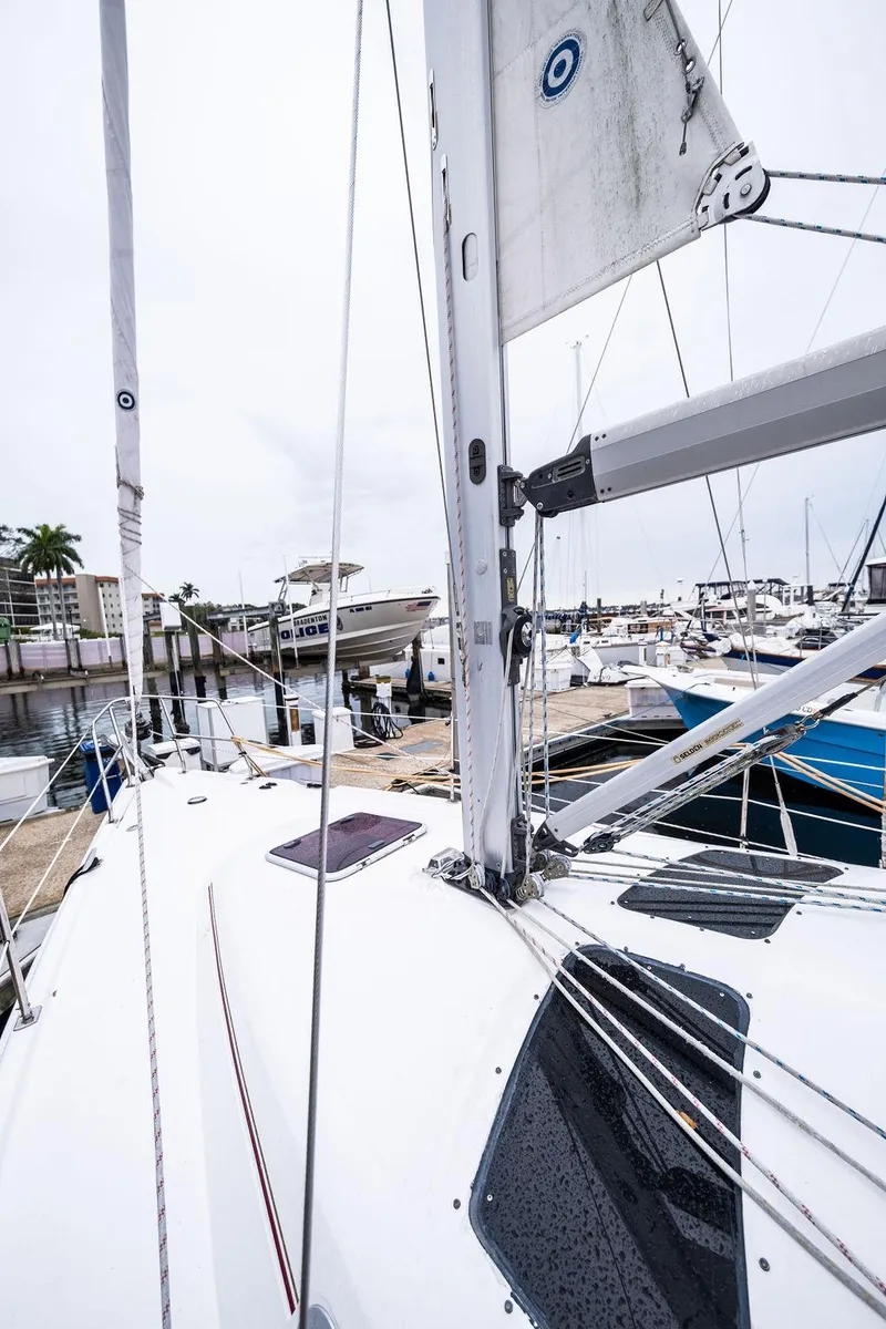 Slide: The Image of 2005 Hunter 38 sailboat docked at marina, showcasing deck and rigging. - 14