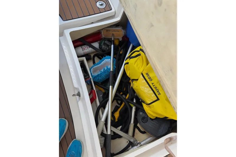 Slide: The Image of Storage compartment on a 2005 Hunter 38 boat with safety gear and cleaning tools. - 35