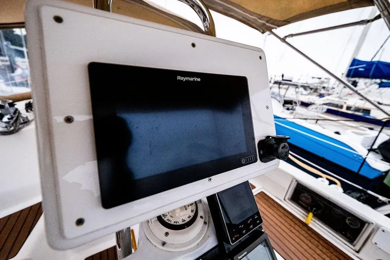 Slide: The Image of Cockpit of 2005 Hunter 38 sailboat with navigation equipment and marina view. - 38