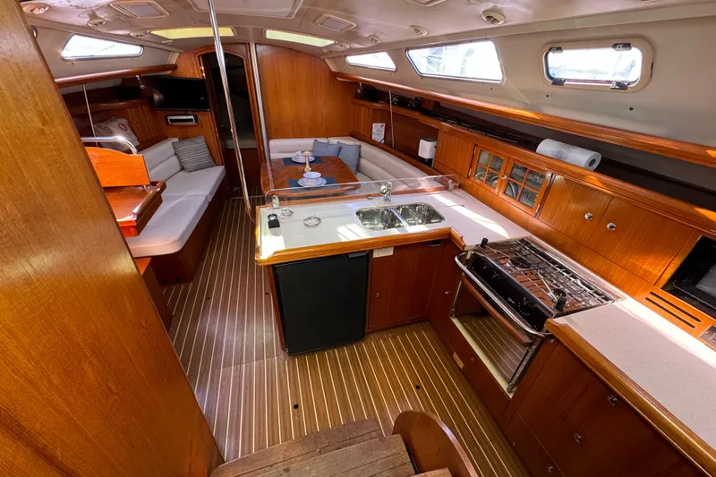 Slide: The Image of Luxurious 2005 Hunter 38 yacht interior with wood finish, kitchen, and seating area. - 42