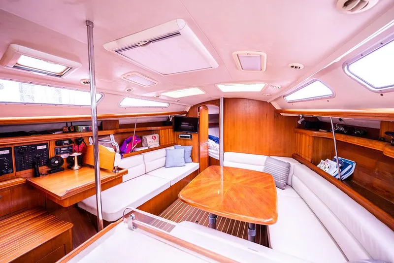 Slide: The Image of Interior of a 2005 Hunter 38 sailboat with wood finish and white seating. - 43