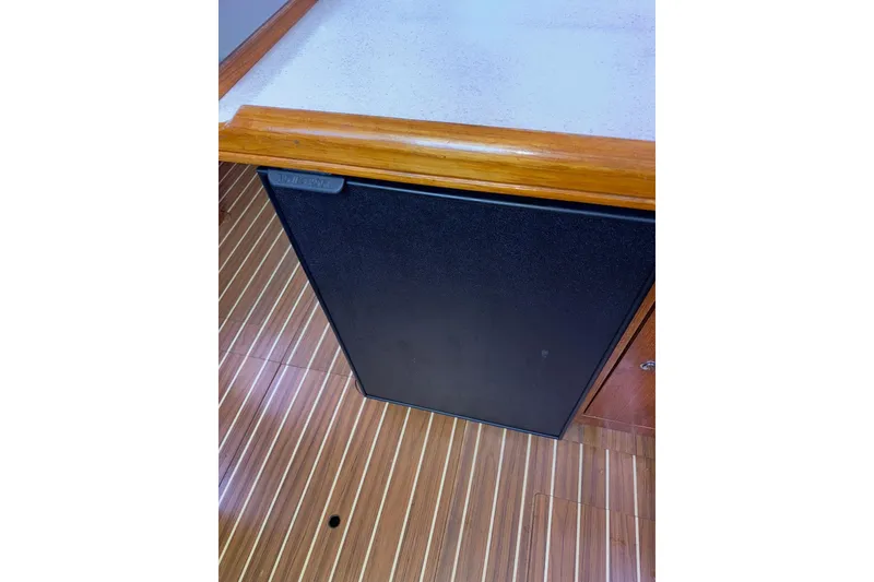 Slide: The Image of 2005 Hunter 38 interior with wooden flooring and compact black cabinet. - 48