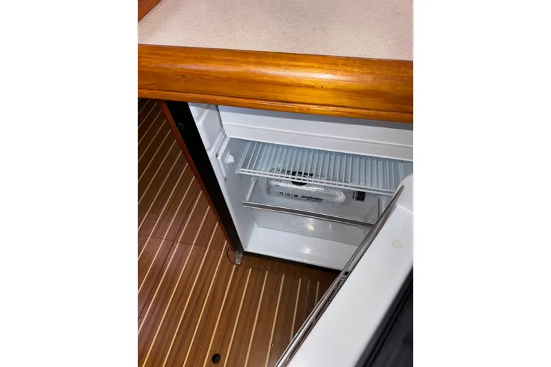Slide: The Image of Open refrigerator in 2005 Hunter 38 yacht, wooden flooring, and countertop visible. - 49