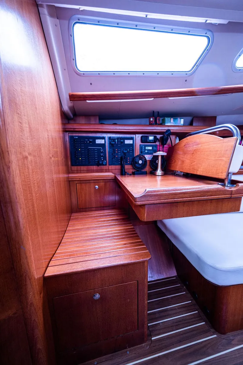 Slide: The Image of Interior of 2005 Hunter 38 sailboat with wooden seating and navigation equipment. - 52