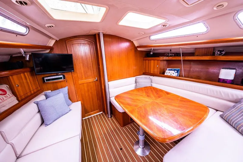Slide: The Image of Luxurious 2005 Hunter 38 yacht interior with wooden dining table and plush seating. - 54